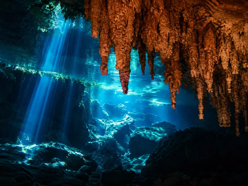 Pristine stalactites and sunbeams inside a deep Yucatan Peninsula cenote cavern formation