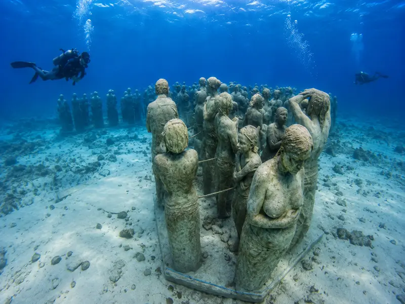 Underwater sculptures covered in coral at the famous MUSA underwater museum site